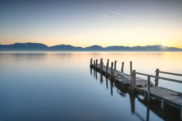Wooden pier or jetty and lake at sunrise. Torre del lago Puccini Versilia Tuscany, Italy - obrazy, fototapety, plakaty