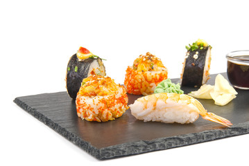 traditional japanese sushi set serviced on black stone. tasty set of sushi, nigiri, sahimi and maki. delicious dinner or lunch for one person. isolated on white