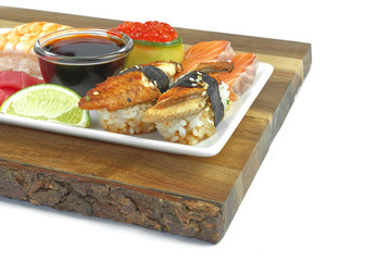 traditional japanese sushi set on a white plate serviced on wood board. tasty set of sushi, nigiri, sahimi and maki. delicious dinner or lunch for one person. isolated on white