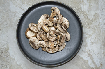 Sliced mini portobello mushrooms on plate. They are also referred to as portabello and are simply the fully mature version of cremini mushrooms. Mushroom is the spore bearing body of a fungus.