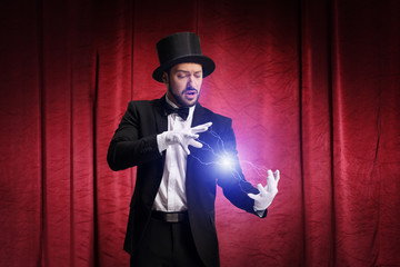 Magician performing a trick and producing electricity on a stage