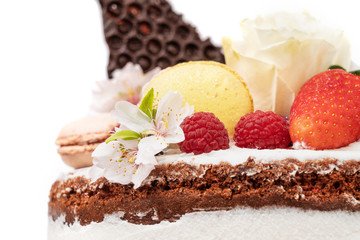 Naked birthday cake with almond flower fruits and marshmallows. Close-up.