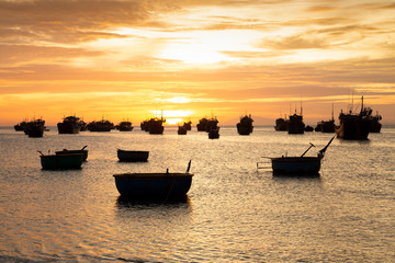 fishing boats silhouettes at sea with perfect sunset backdrop and copy space wide angle view