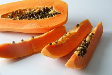 Half and slices papaya isolated on white.