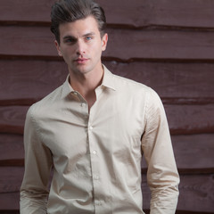 Portrait of handsome young man on wooden background.