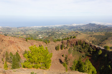 Fototapeta na wymiar Scenic natural landscape with arid valley, vegetation and sea on background in Gran Canaria, Spain. Diversity nature formation on sunny day in Canary Islands