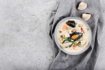 Clam chowder in a gray plate. The main ingredients are shellfish, broth, butter, potatoes and onions. - obrazy, fototapety, plakaty