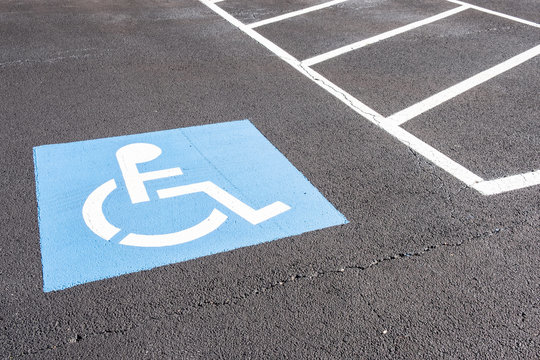 Disabled parking permit sign painted on the street