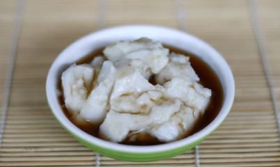 Bubur sumsum on bambbo background. Indonesian traditional porridge made from rice flour served with brown sugar syrup.