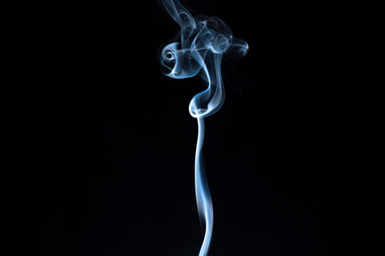 White and blue smoke on black background. Cigarette smoke.