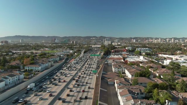 Aerial view of road signs, freeway and interstate traffic at I-405 and I-10 intersection in urban West Los Angeles with cars below on a sunny day.