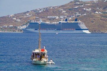 Celebrity Cruises cruiseship or cruise ship liner in port Of mykonos with sailing boat or yacht on...