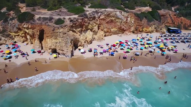 Aerial top view of tourists resting on the beach Alemao Vau, Boia, tres irmaos, Portimao Algarve coast. Portugal.
