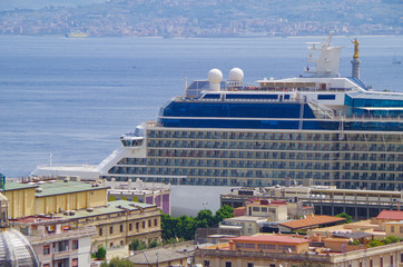 Modern cruiseship or cruise ship liner in port of Messina, Sicily with mainland Italy in background...