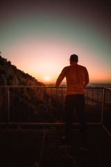 Fototapeta premium Man on top of mountain watching the sunrise . Conceptual scene.