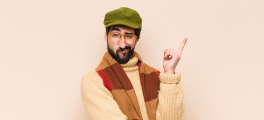 young cool bearded man feeling like a genius holding finger proudly up in the air after realizing a...