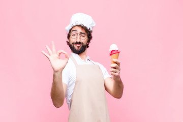 young crazy chef man with an ice cream against pink wall