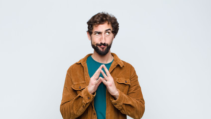 young handsome man scheming and conspiring, thinking devious tricks and cheats, cunning and...