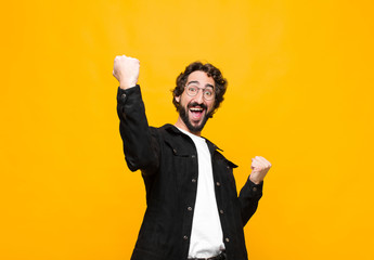 young crazy handsome man shouting triumphantly, looking like excited, happy and surprised winner,...