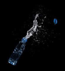 Bottle of drinking water splashing out isolated on black