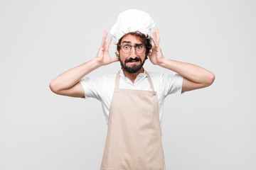 young crazy chef feeling stressed, worried, anxious or scared, with hands on head, panicking at...