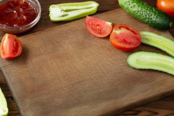Wooden cutting board with tomatoes, cucumbers and empty space