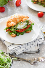 Croissant fish and poached egg sandwich