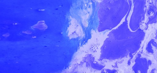 Abstract violet-blue marble background. Natural stone texture. Acrylic paint flows freely and...
