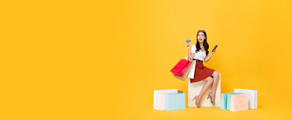 Woman carrying shopping bags with credit card on banner background