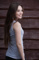 Fototapeta premium Portrait of beautiful young girl on wooden background.