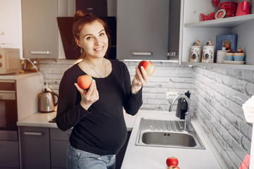 Elegant girl in a kitchen. Woman with fruits.