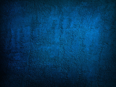 Abstract blue background. Dark blue grunge background. Rough grainy concrete wall surface texture. Deep blue concrete backdrop.