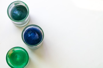 Glasses with frozen colored water on a white background. Background with place for text.