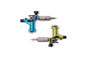 Blue and green tattoo machines isolated on white background