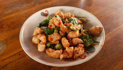 Thai style spicy fish ball stir fried with mint leaves and chili pepper serving on white plate