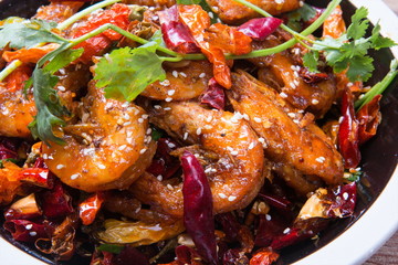 This is an Asian cuisine where you take the shrimp and you fry it, you add the chili, the white sesame, the sichuan peppercorn and then you pour the beer inside