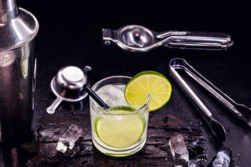 Brazilian caipirinha, typical Brazilian cocktail made with lemon and sugar with cachaça or vodka. Drink with black background and space for text.