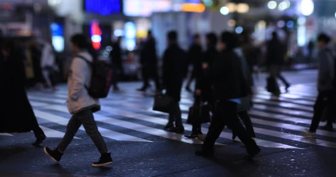 Walking people at the crossing in Shinjuku Tokyo rainy day at night