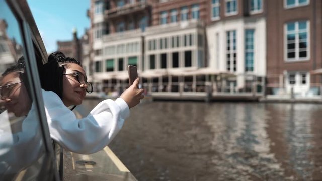 Woman shoots amsterdam at camera through window of yacht