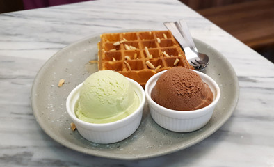 Fresh homemade baked waffle serving with homemade ice-cream on grey color plate