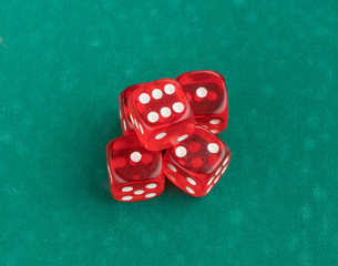 group of red playing dice on a green background, isolated. top view