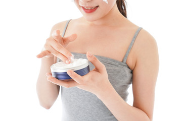 顔にクリームを塗る若い女性