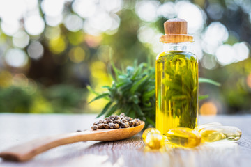 CBD hemp oil, hemp seeds in a wooden spoon And the tablets of the salad from CBD oil placed on the table, natural background Alternative medicine concepts Natural herbs.