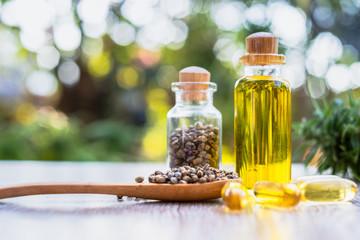 CBD hemp oil, hemp seeds in a wooden spoon And the tablets of the salad from CBD oil placed on the table, natural background Alternative medicine concepts Natural herbs.