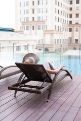 Asia beautiful woman relaxing on lounger near swimming pool in hotel