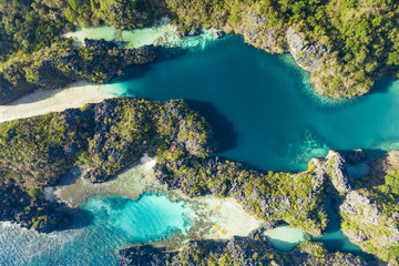 View from above, aerial view of the Big Lagoon and the Small Lagoon, two beautiful bays of crystal clear water surrounded by rocky cliffs. Miniloc Island, Bacuit Bay, El Nido, Palawan, Philippines.