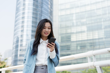 Young white-collar workers use mobile phones in the business district