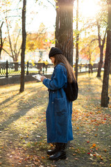 Beautiful young female student is studying using a tablet in a park. Recreation and study concept