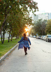girl in stylish hipster outfit running and having fun. Exiting emotions. Autumn mood. Wearing gray...