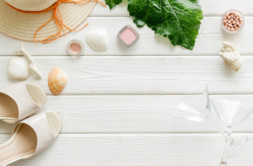 Female outfit. Clothes, shoes, cosmetics on white wooden background top-down frame copy space